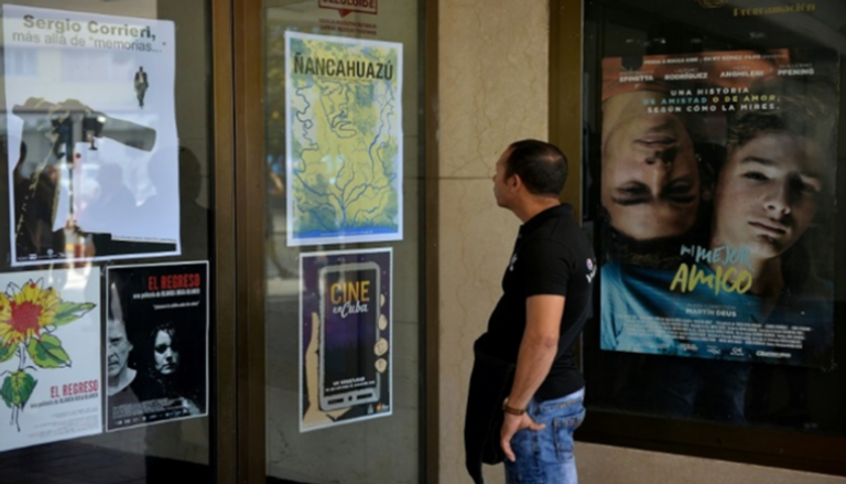 رجل أمام ملصقات أفلام خلال مهرجان "هافانا آي فيلم فيستيفال"