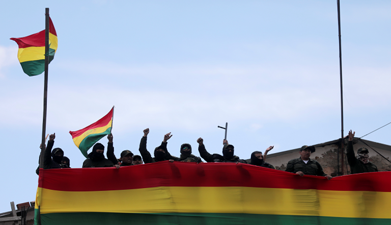 رجال شرطة ينضمون للمعارضة متظاهرون في أحد شوارع بوليفيا