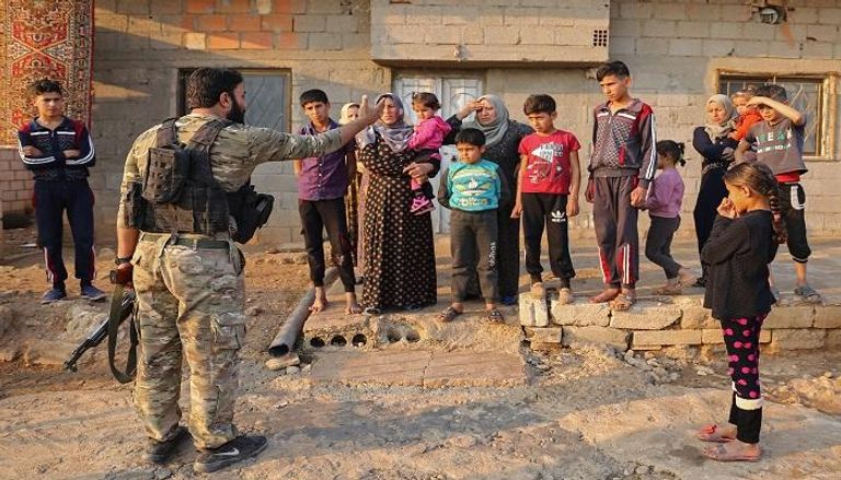 جندي موالي لتركيا يهدد عدد من المدنيين الأكراد - أ.ف.ب 
