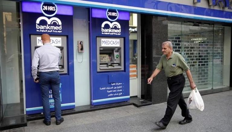 لبناني يمر أمام بنك مغلق في بيروت - رويترز