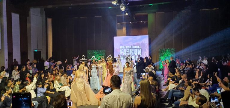 المصممة الإماراتية العالمية منى المنصوري وسط مشاركين بحفل الافتتاح 