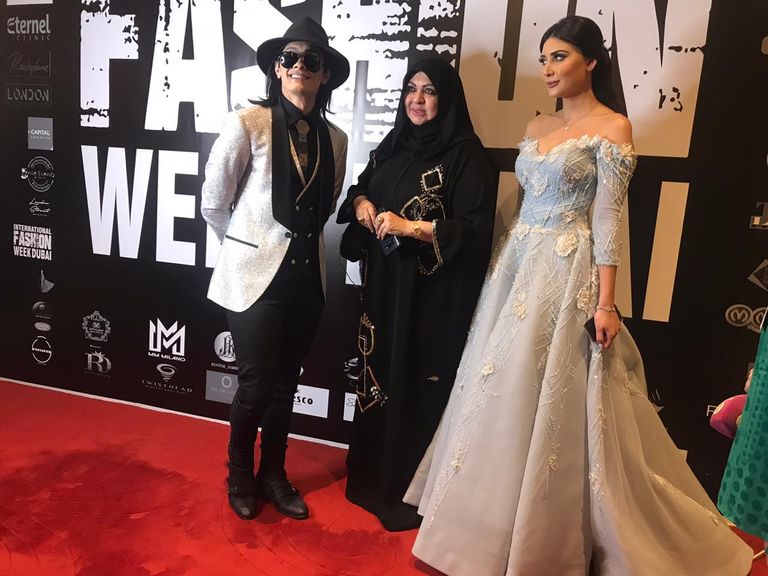 المصممة الإماراتية العالمية منى المنصوري وسط مشاركين بحفل الافتتاح 