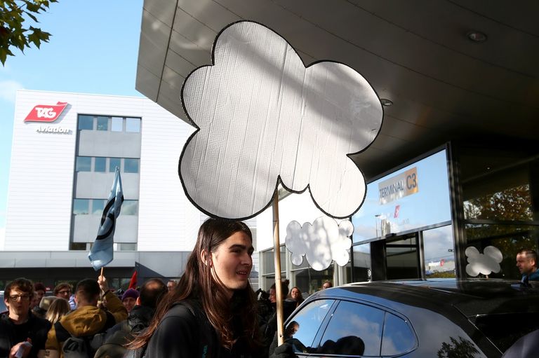 النشطاء يجلسون أمام مبنى مدرج الطائرات الخاصة بمطار جنيف