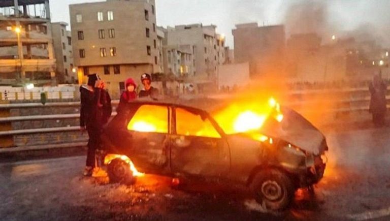 محتجون يضرمون النار في سيارات للشرطة الإيرانية
