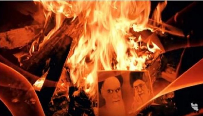  متظاهرون إيرانيون يحرقون صور مرشد إيران السابق والحالي - أرشيفية 