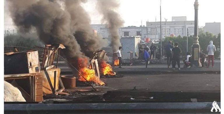 عراقيون يغلقون أحد الشوارع في محافظة النجف