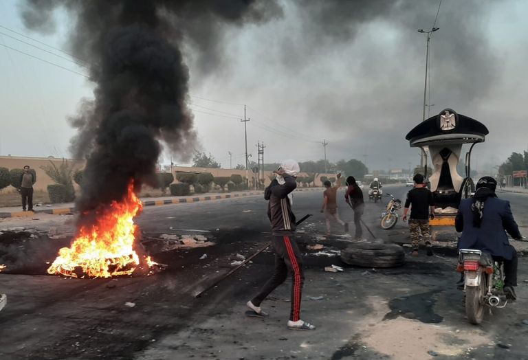 عراقيون يغلقون أحد الشوارع في محافظة النجف