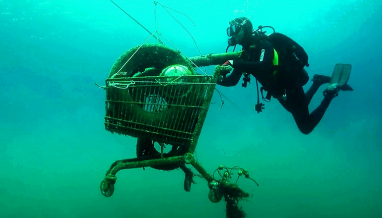 غواص متطوع يسحب عربة تسوق ألقيت في أعماق البحر بجزيرة يونانية