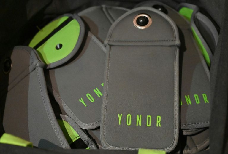 شخص يسلم هاتفه عند مدخل معرض ببروكلين