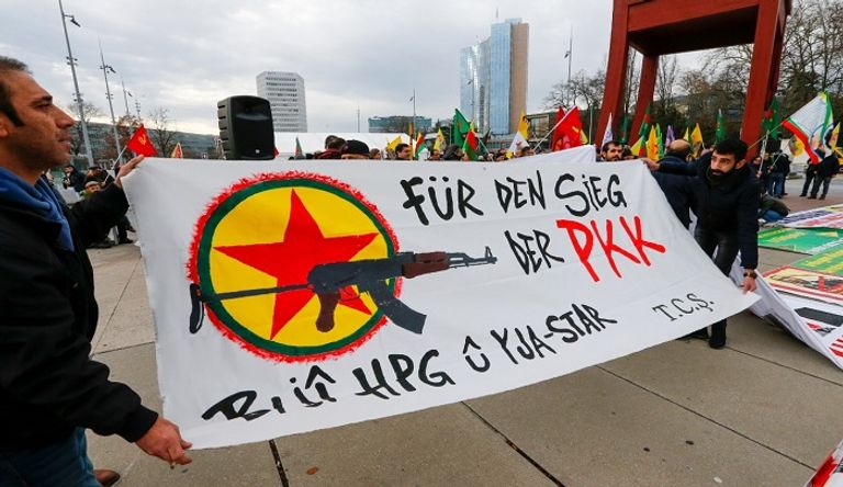 متظاهرون في جنيف يحملون لافتة 