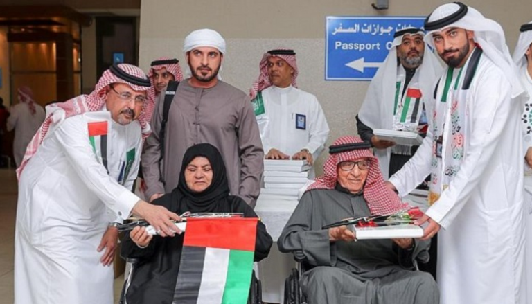 توزيع أعلام السعودية والبحرين على المسافرين