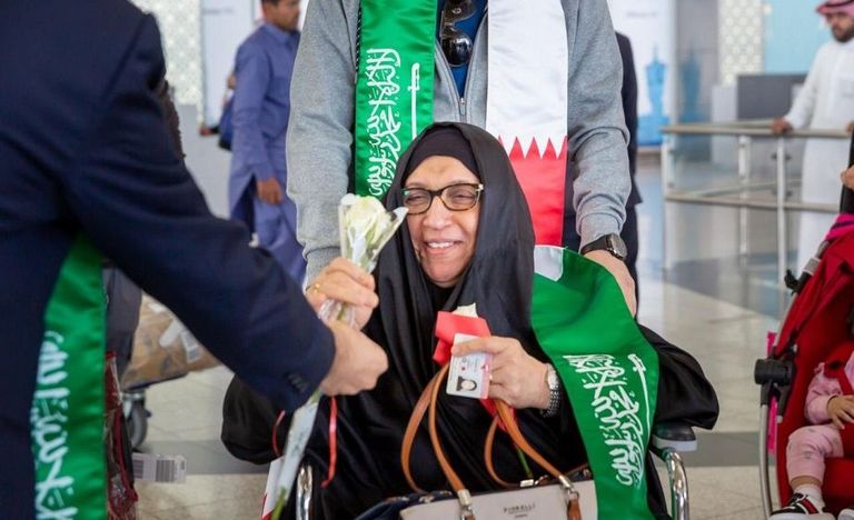 توزيع أعلام السعودية والبحرين على المسافرين