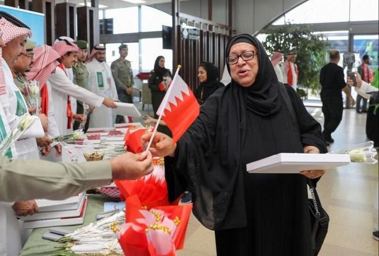 توزيع أعلام السعودية والبحرين على المسافرين