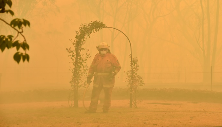 رجل إطفاء أثناء محاولة إخماد الحرائق - أ.ف.ب