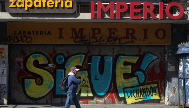 رجل يمر من أمام أحد المتاجر في فالباراسيو بتشيلي