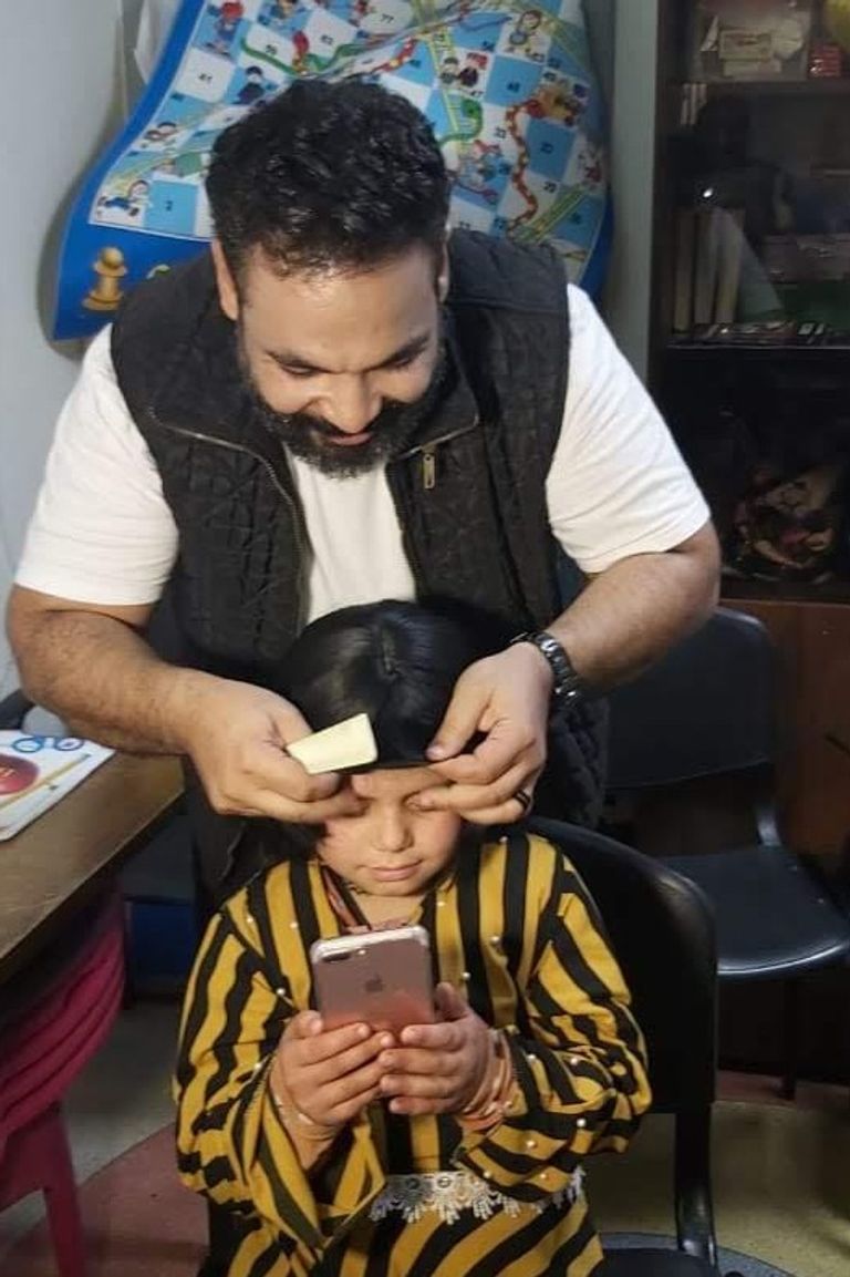 سامح سلام يجرب تركيب شعر مستعار لطفلة مصابة بالسرطان