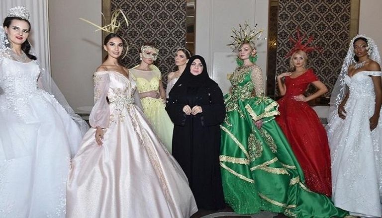 مصممة الأزياء الإماراتية منى المنصوري تتوسط مجموعة من العارضات 