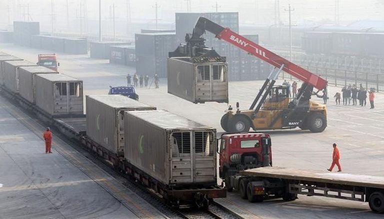 عمال يفرغون حاويات في بكين - رويترز