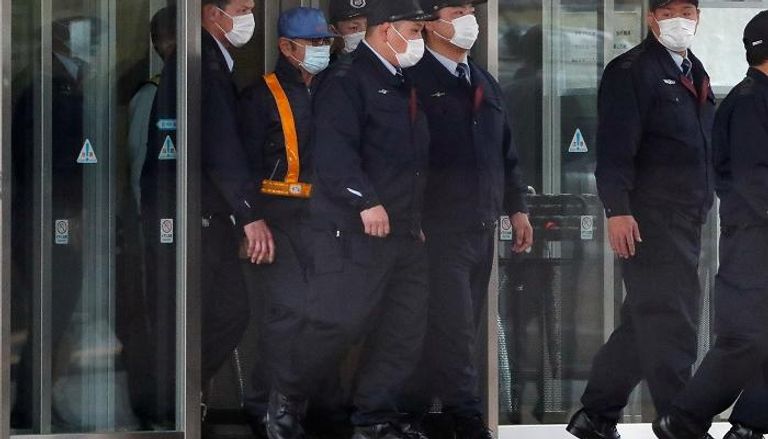   غصن (وهو يرتدي قبعة زرقاء) يغادر مقر معتقل طوكيو –رويترز