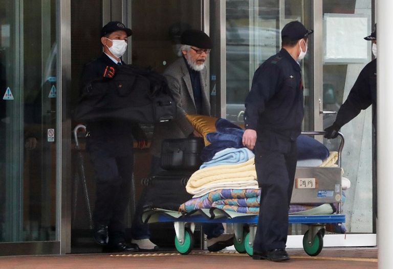 متعلقات غصن خلال توقيفه   غصن  يرتدي قبعة زرقاء وهو يغادر مقر التوقيف في طوكيو –رويترز