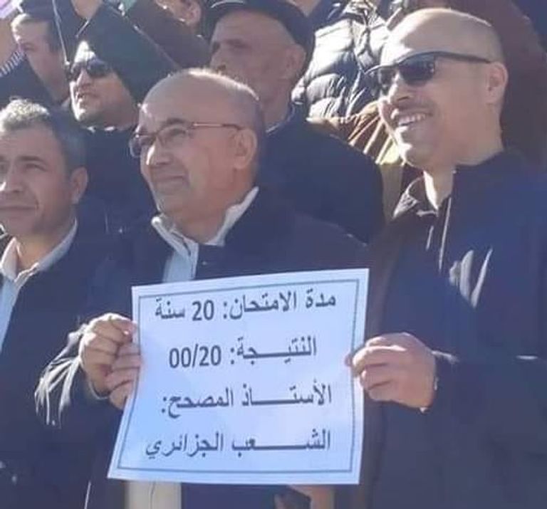 جزائريون يحملون لافتات في مظاهراتهم الأخيرة مكتوب عليها عبارات ساخرة جزائريون يحملون لافتات يسخرون بها من الوضع السياسي في بلادهم