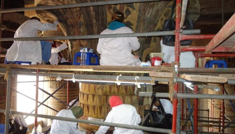 فريق ترميم مصري يقوم بتنظيف وترميم سقف معبد إسنا