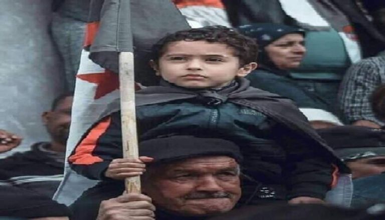 طفل يحمل راية الجزائر على ظهر جده في مظاهرات الجمعة