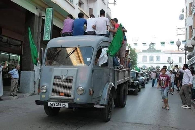 جزائريون يعيديون تجسيد وقائع استقلال الجزائر طفل يحمل راية الجزائر على ظهر جده في مظاهرات الجمعة