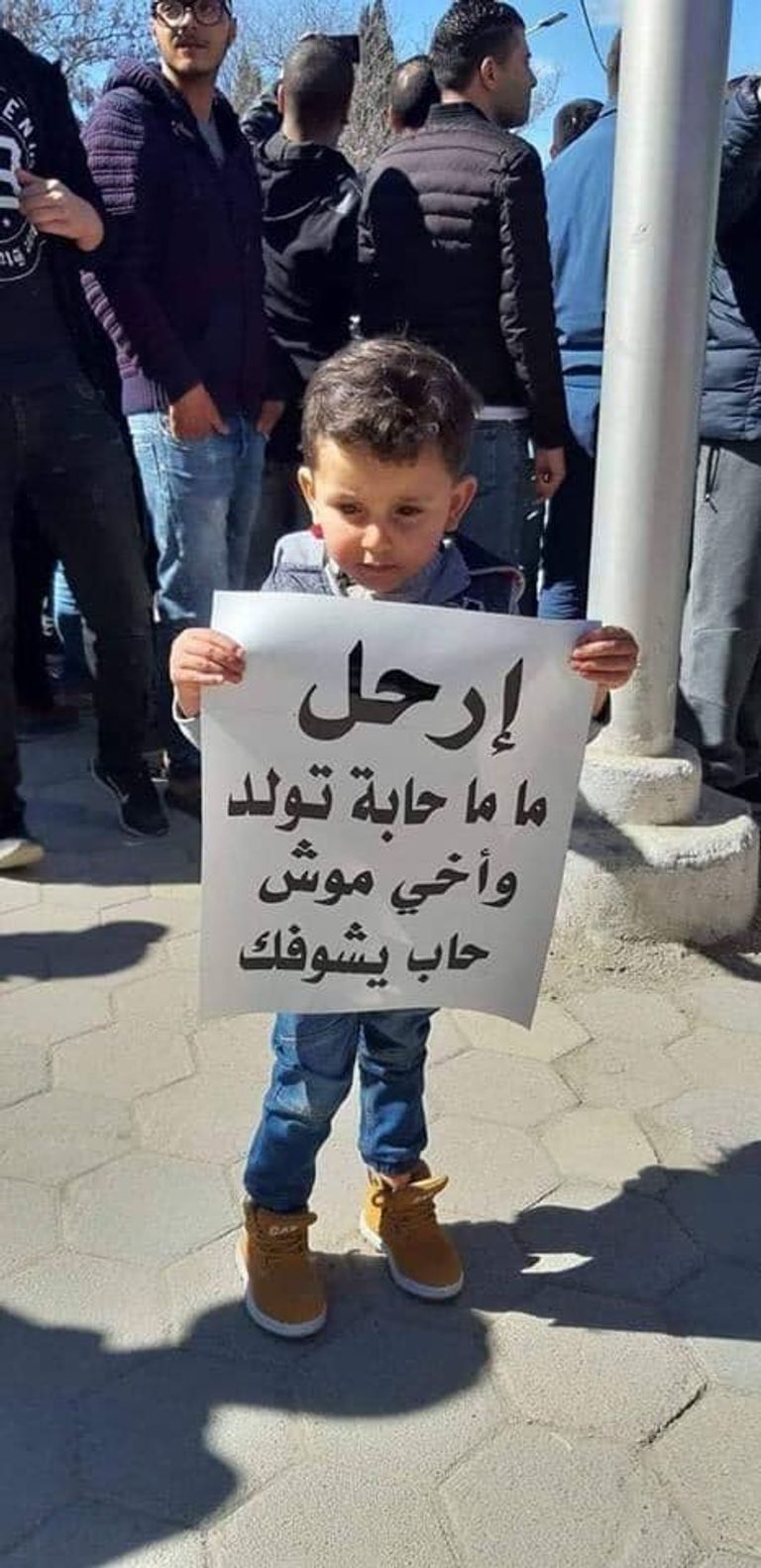 لافتات الجزائريين في مظاهراتهم طفل يحمل راية الجزائر على ظهر جده في مظاهرات الجمعة