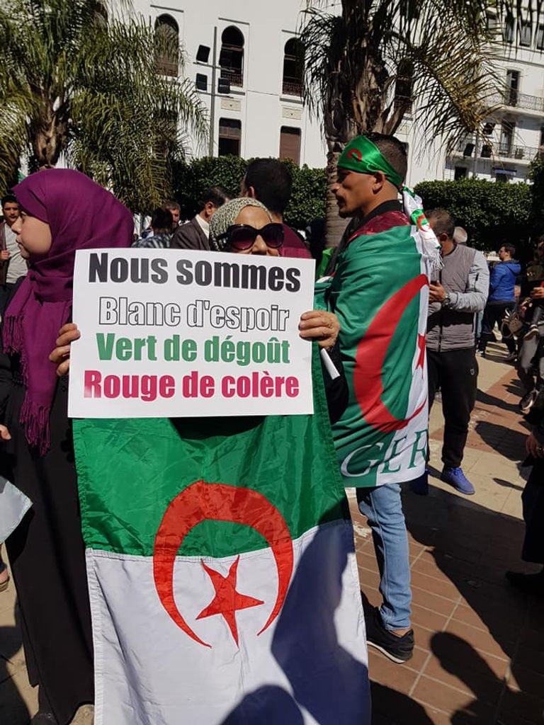 لافتات الجزائريين في مظاهراتهم طفل يحمل راية الجزائر على ظهر جده في مظاهرات الجمعة