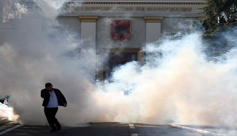 متظاهر يلقي قوات الشرطة بالحجارة أمام مقر البرلمان بألبانيا - أرشيفية