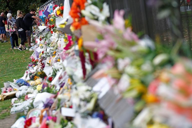 الناس يضعون الزهور في نصب تذكاري تكريما لضحايا الهجوم بالقرب من المسجد