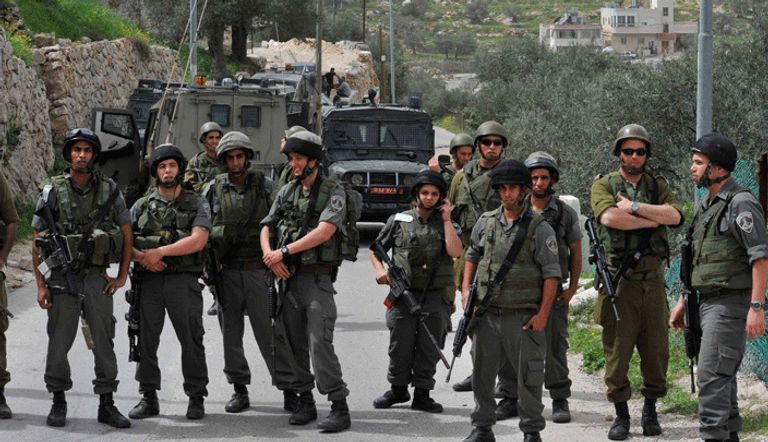 جنود من جيش الاحتلال يغلقون طريقا بالضفة  صورة أرشيفية لحاجز إسرائيلي مغلق في الضفة