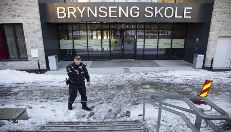 أحد أفراد الشرطة النرويجية أمام المدرسة