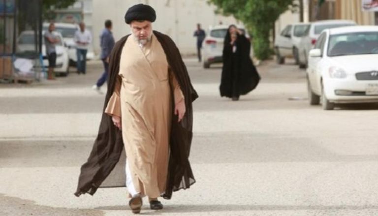 أحد أتباع مقتدى الصدر يرفع صورته