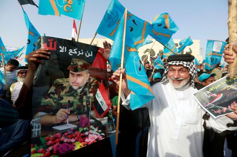 أحد أتباع مقتدى الصدر يرفع صورته