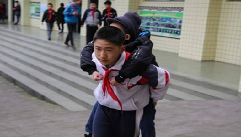  الطالب الصيني "زو بينجيانج" يحمل زميله على ظهره كل يوم إلى المدرسة