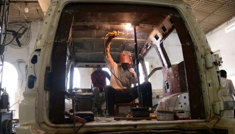 عمال ينجزون مهام تصفيح سيارة بمدينة جالاندهار الهندية