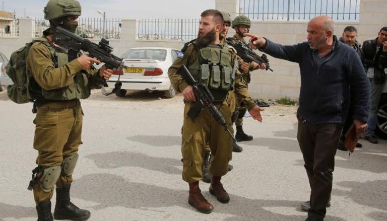 قوات الاحتلال مدججة بالسلاح أمام فلسطيني بالضفة-أرشيفية