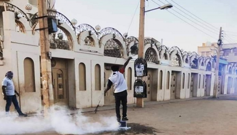 أحد متظاهري السودان يتصدى لقنابل الغاز المدمع