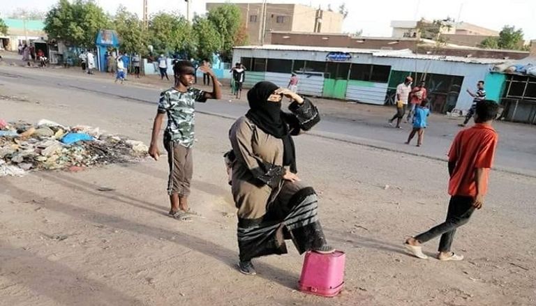 أحد متظاهري السودان يتصدى لقنابل الغاز المدمع