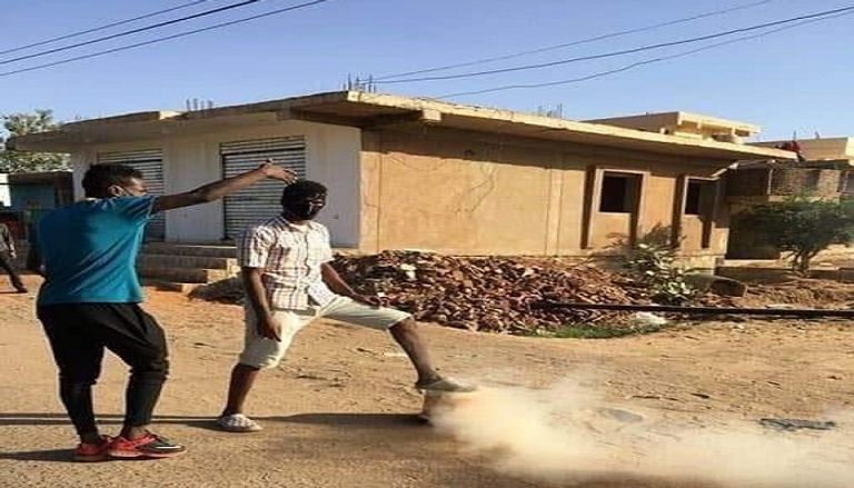 أحد متظاهري السودان يتصدى لقنابل الغاز المدمع