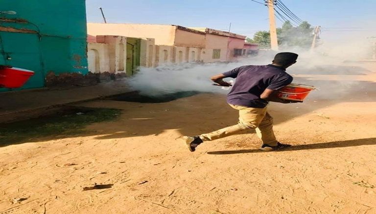 أحد متظاهري السودان يتصدى لقنابل الغاز المدمع
