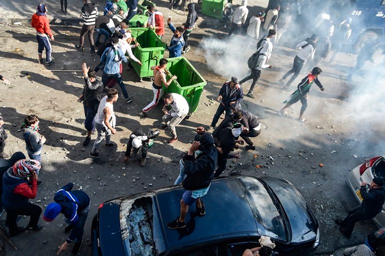مواجهات حادة بين قوات الأمن الجزائرية ومتظاهرين مجهولون يضرمون النار في سيارة للأمن