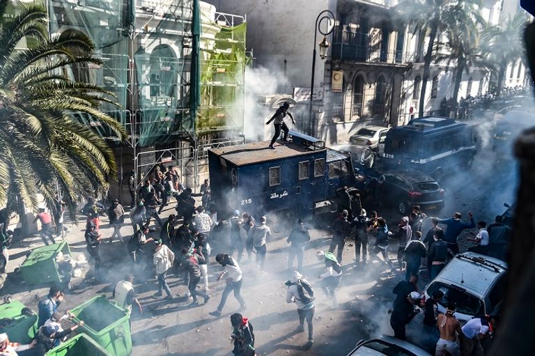 مواجهات حادة بين قوات الأمن الجزائرية ومتظاهرين مجهولون يضرمون النار في سيارة للأمن