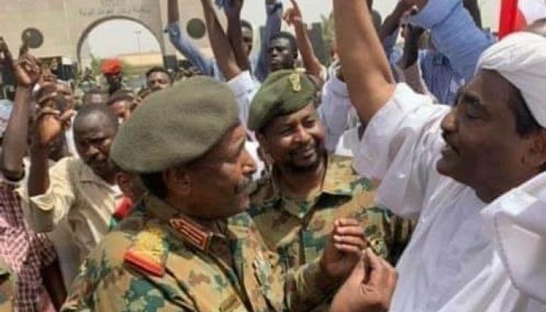 رئيس المجلس الانتقالي العسكري وسط متظاهرين سودانيين