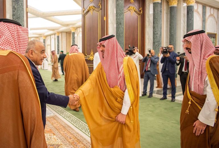 العاهل السعودي خلال استقباله رئيس وزراء العراق