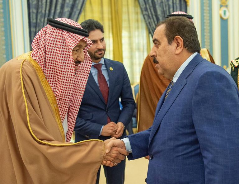 العاهل السعودي خلال استقباله رئيس وزراء العراق