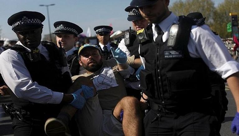 الشرطة البريطانية أثناء اعتقالها أحد المحتجين.