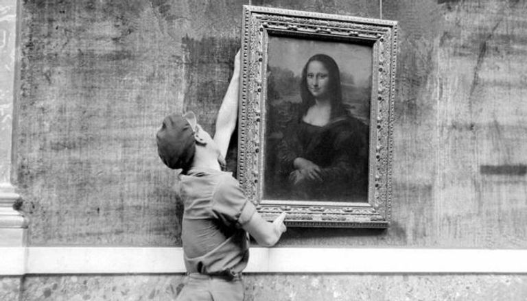موظف من اللوفر يعلق لوحة الموناليزا لليوناردو دافينشي عام 1947